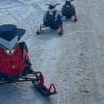 3 Snowmobiles on side of road